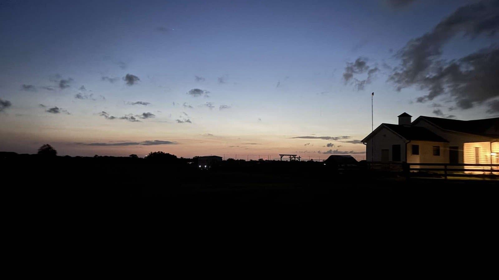Twilight over the fields with the farmhouse lit up