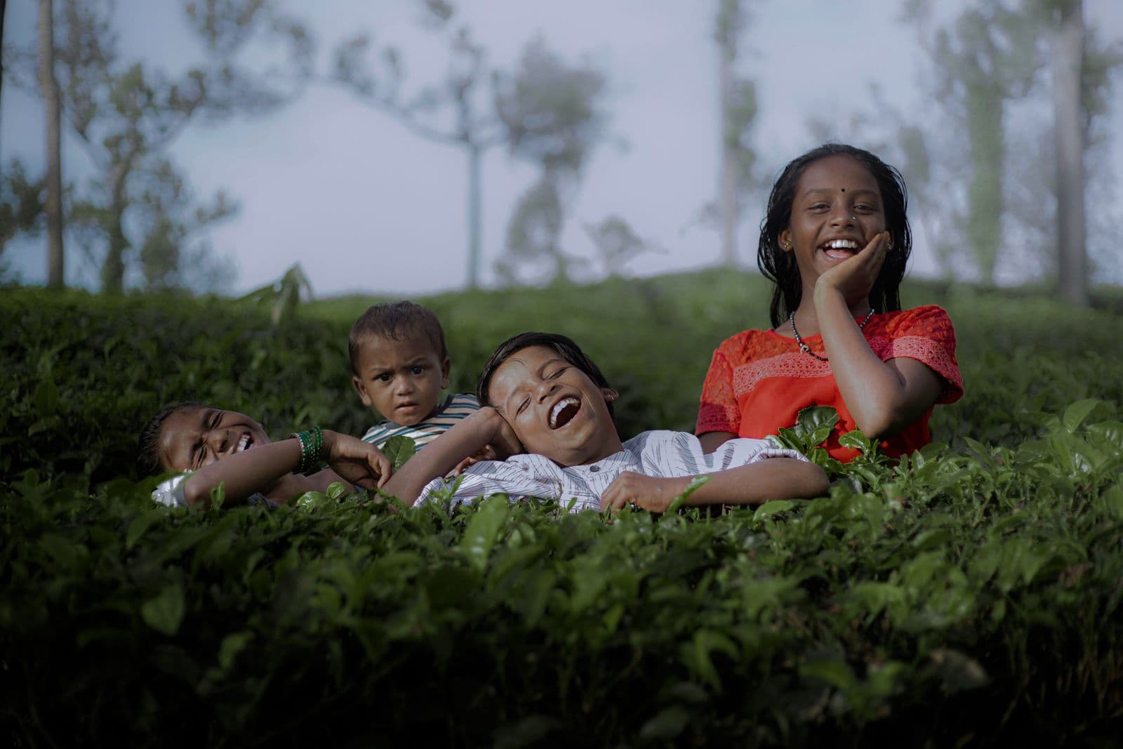 Children laughing together outdoors on a bright day at the farm